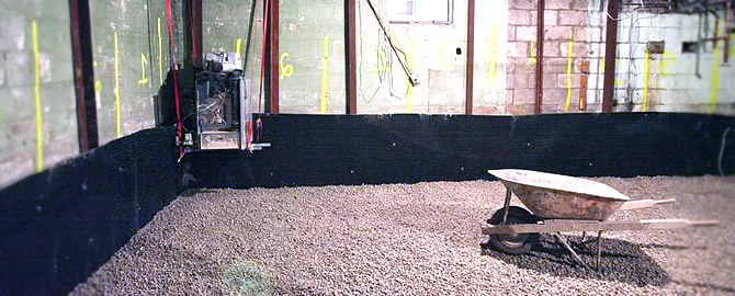 foundation underpinning in the basement of a toronto home with wheel barrow and gravel on the ground