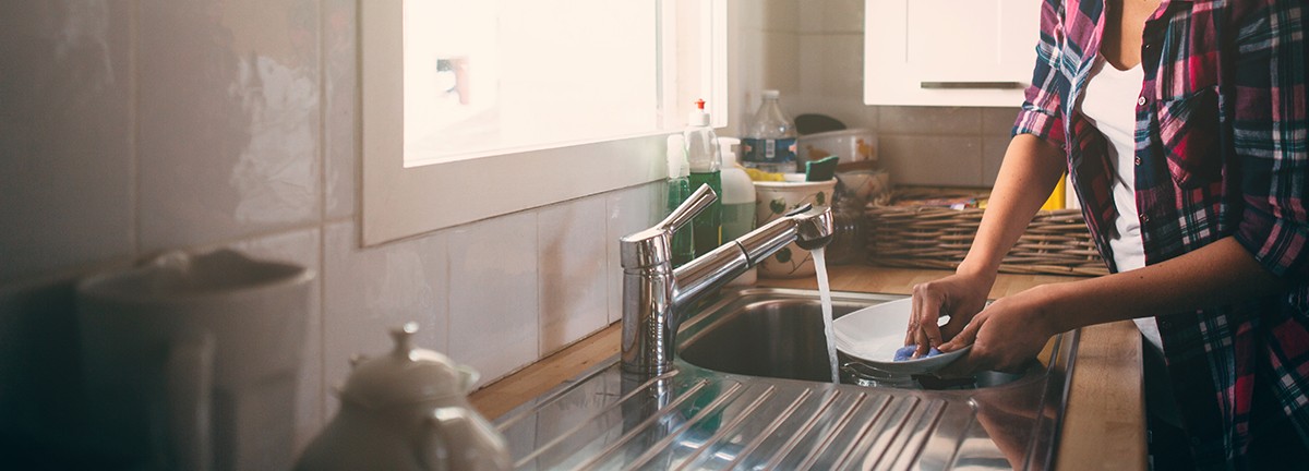 beautiful kitchen with lovely woman cleaning dishes in the kitchen sink